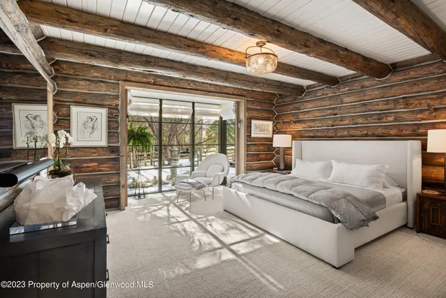 a spacious bedroom with a bed a table and chairs