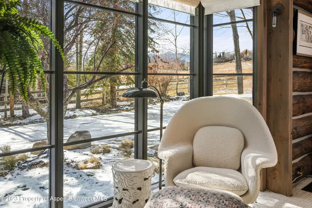 a living room with a large window and furniture