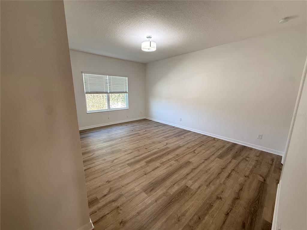 7605 Ripplepointe Way Windermere, FL 34786 - Photo 17 of 27 an empty room with wooden floor and windows