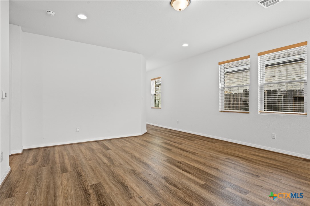 448 Chaste Tree Drive San Marcos, TX 78666 - Photo 13 of 31 an empty room with wooden floor and windows