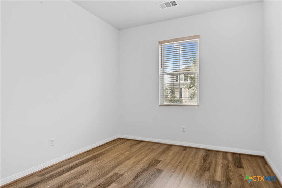 448 Chaste Tree Drive San Marcos, TX 78666 - Photo 4 of 31 a view of an empty room with wooden floor and a window