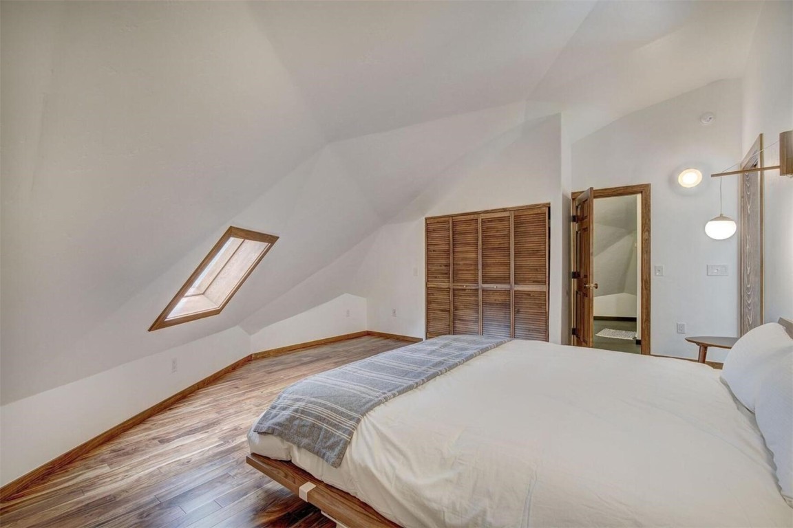 53 Blue Ridge Road Breckenridge, CO 80424 - Photo 22 of 30 Spacious Primary suite bedroom featuring hardwood flooring, a closet, lofted ceiling and primary bath