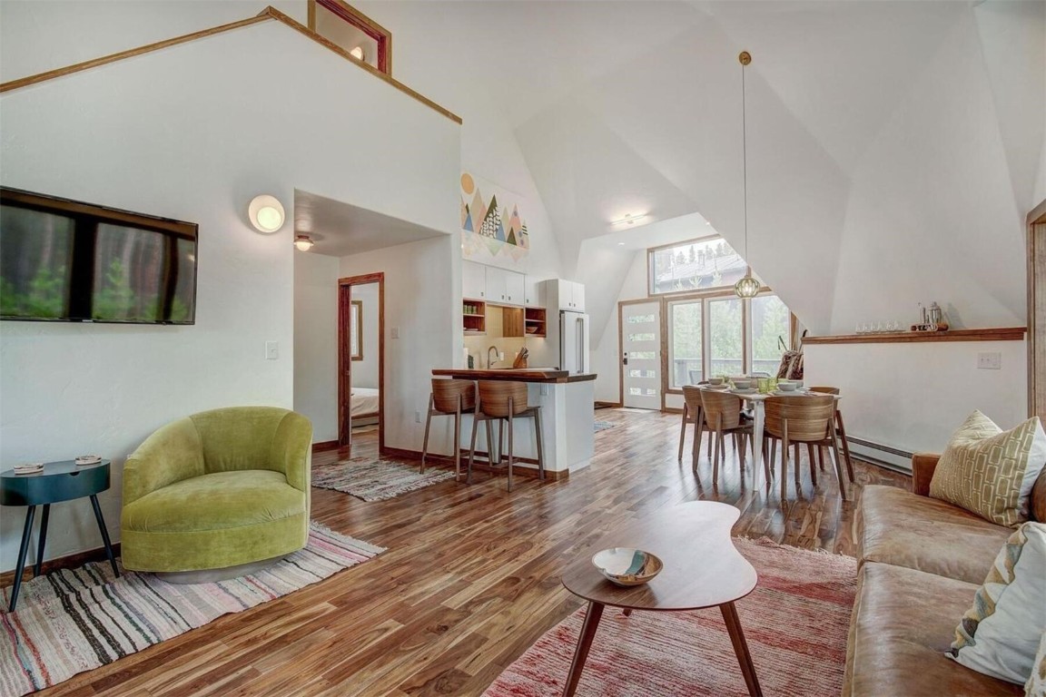Living room featuring a high vaulted ceiling, and hardwood flooring