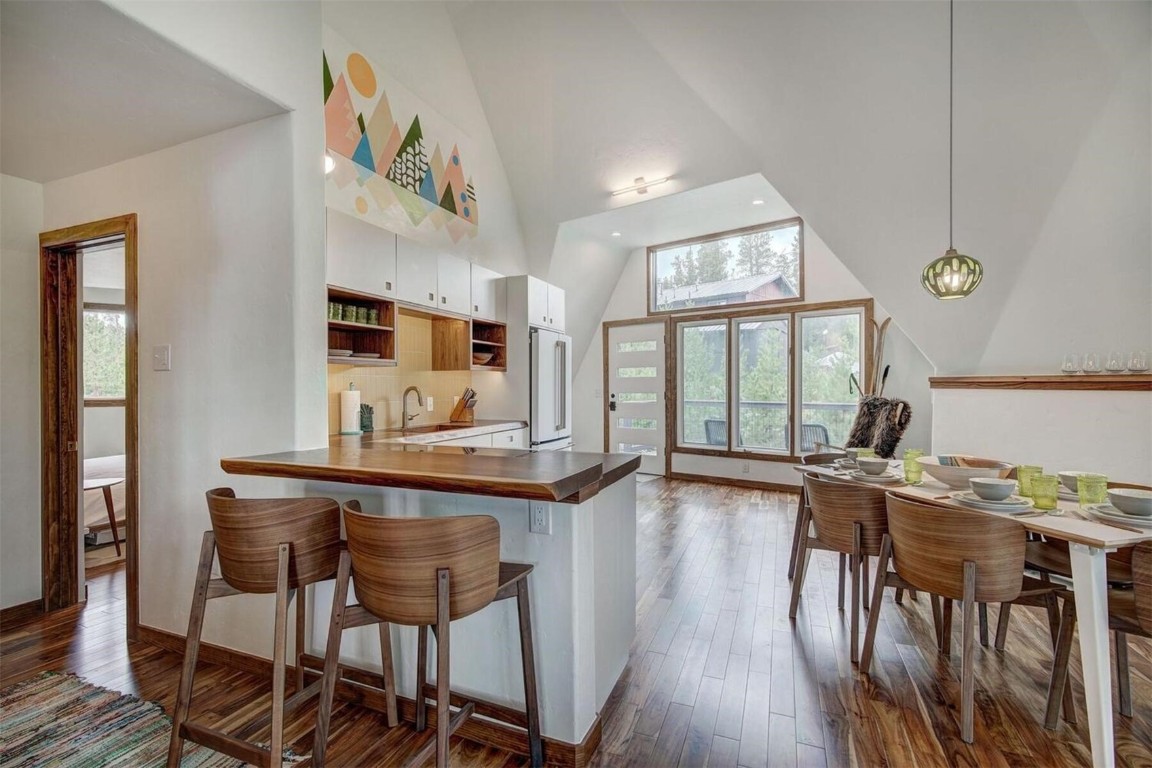 Kitchen featuring white cabinetry, kitchen peninsula, plenty of natural light, and decorative light fixtures