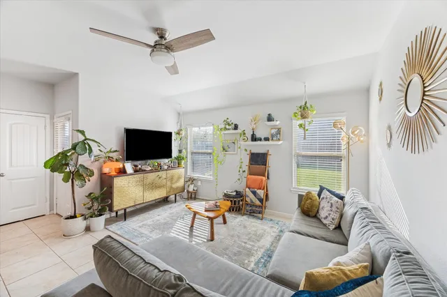 a living room with furniture a flat screen tv and a table