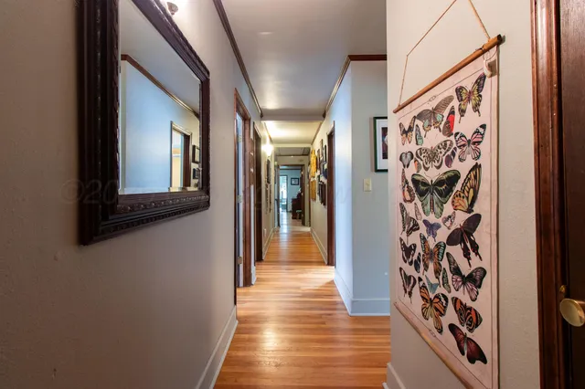 a view of a hallway with wooden floor and stairs