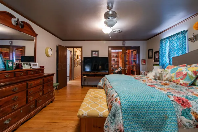 a bed room with a bed mirror and a flat tv screen
