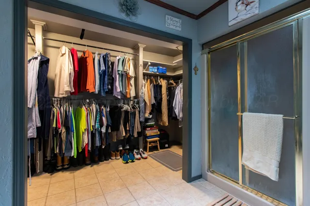 a view of walk in closet with clothes and shoes