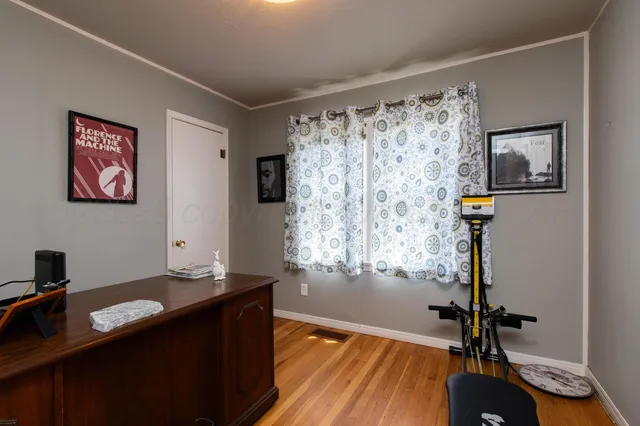 a view of a workspace with furniture and a window