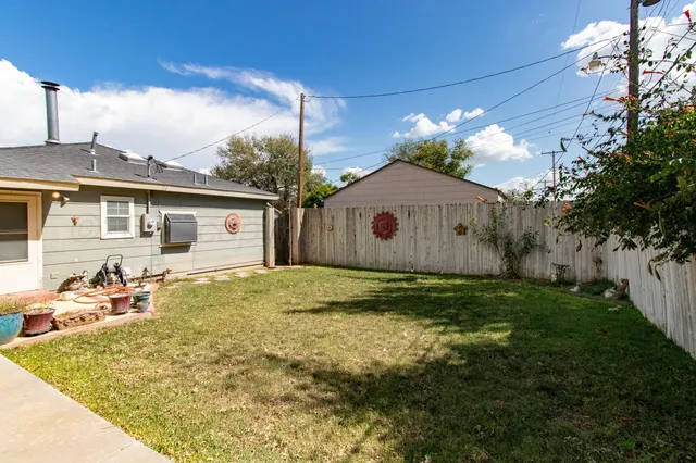 a view of a house with backyard sitting area and garden