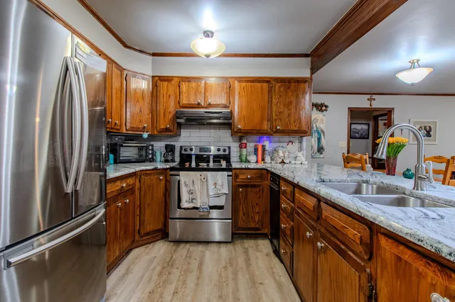 a kitchen with stainless steel appliances a sink window and cabinets