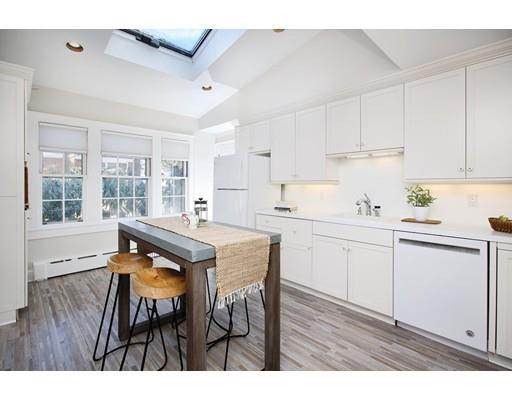 121 Intervale Road Newton, MA 02467 - Photo 7 of 14 a kitchen with stainless steel appliances kitchen island wooden floors and white cabinets