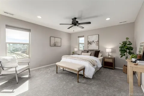 a spacious bedroom with a bed and a chair