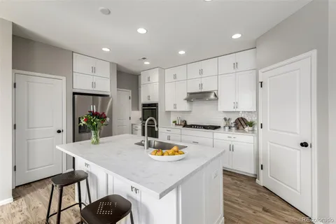 a kitchen with refrigerator cabinets and wooden floor
