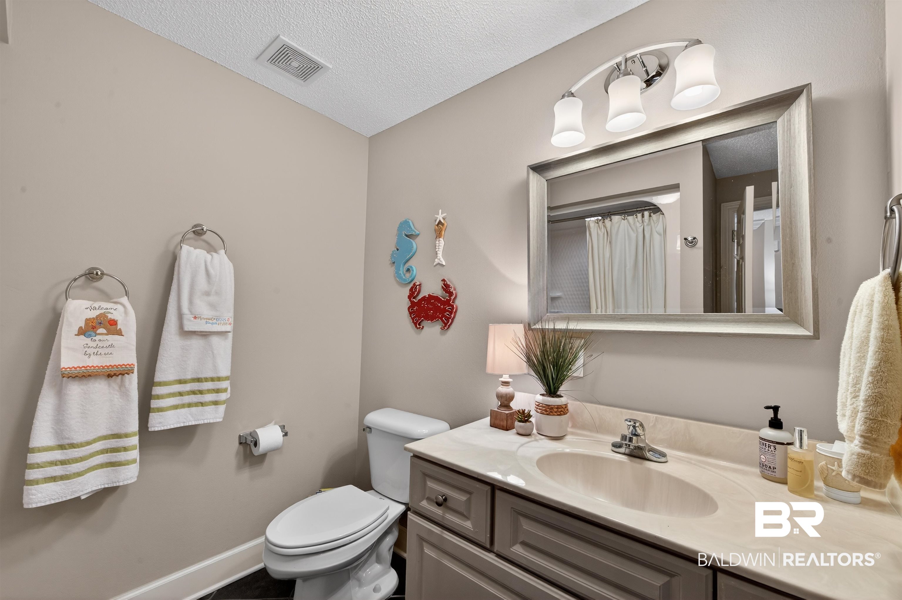 27582 Canal Road, Unit 2507 Orange Beach, AL 36561 - Photo 40 of 75 Full bathroom with vanity, curtained shower, and a textured ceiling