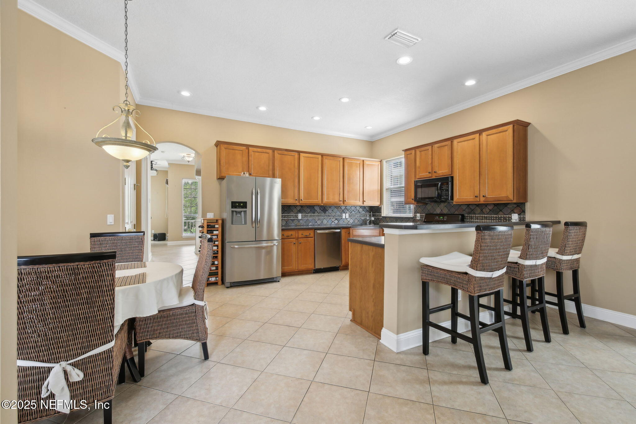 400 Central Street St. Augustine, FL 32095 - Photo 16 of 49 a kitchen with stainless steel appliances kitchen island granite countertop a table chairs microwave and sink