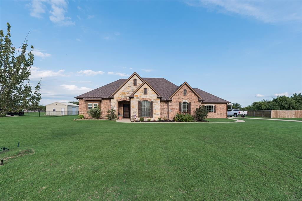1132 Chartres Street Kaufman, TX 75142 - Photo 25 of 25 Brick and stone facade residence featuring a prominent front gable, dark shingle roof, and an expansive green lawn