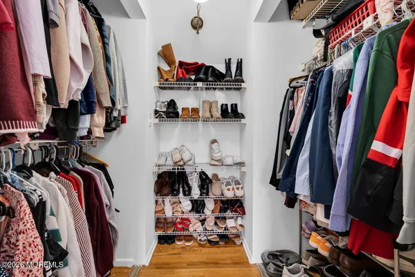 a view of walk in closet with clothes and shoes