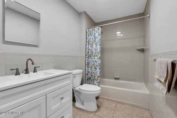 a bathroom with a bathtub shower sink vanity and toilet