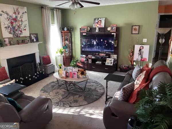 a living room with furniture a flat screen tv and a fireplace