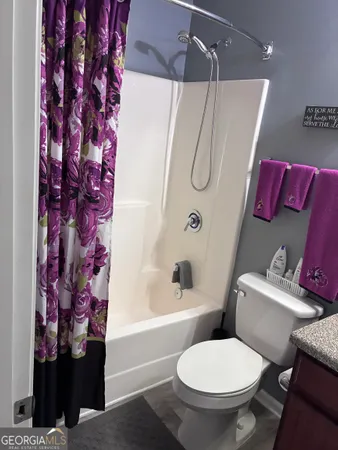 a white toilet sitting next to a bath tub and shower