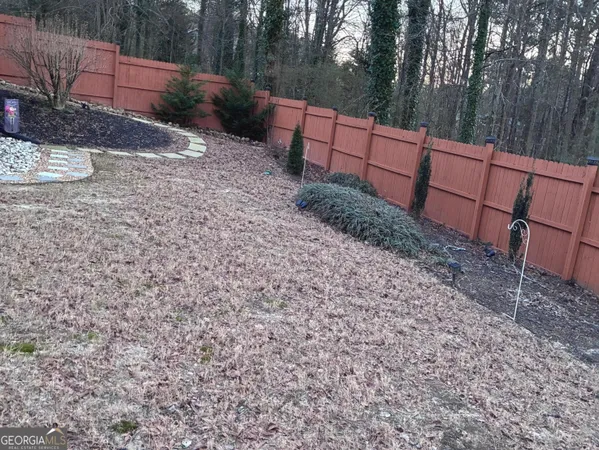 a view of backyard with wooden fence