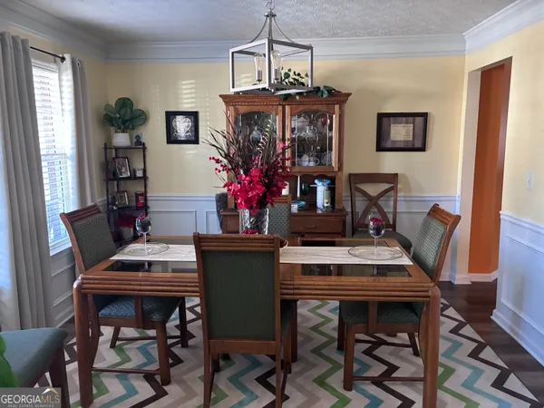 a view of a dining room with furniture and a chandelier