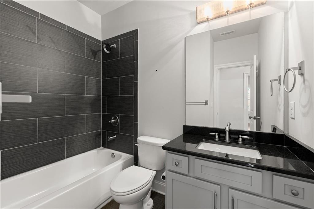 1868 Skyfall Circle Atlanta, GA 30319 - Photo 45 of 61 a bathroom with a granite countertop sink a toilet and shower