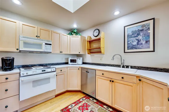 a kitchen with stainless steel appliances granite countertop a stove sink and cabinets