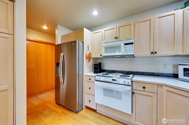 a kitchen with stainless steel appliances white cabinets and a stove top oven