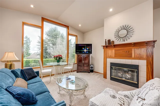 a living room with furniture a large window and a fireplace