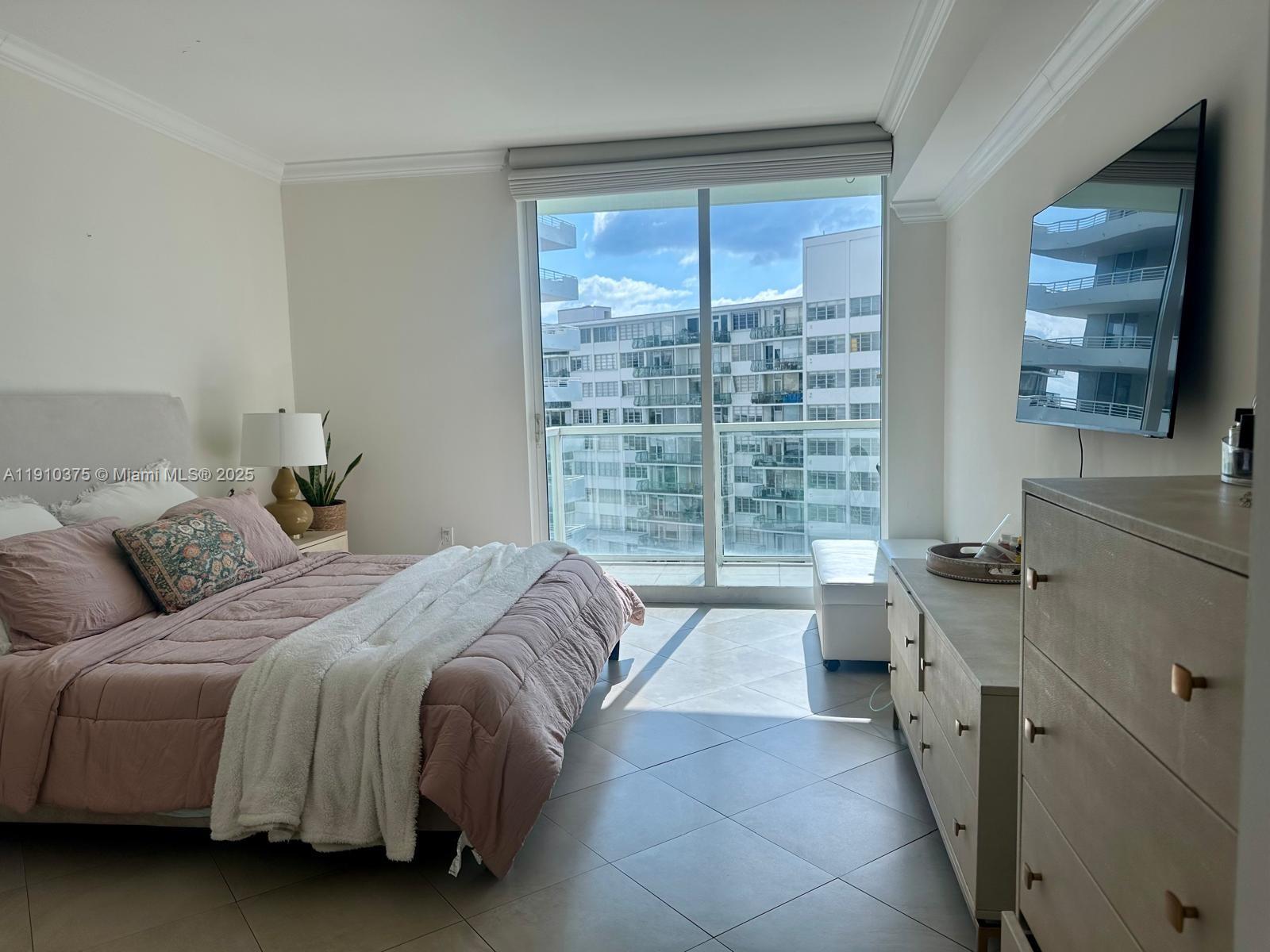 218 Southeast 14th Street, Unit 1003 Miami, FL 33131 - Photo 11 of 27 a spacious bedroom with a large bed and a large window
