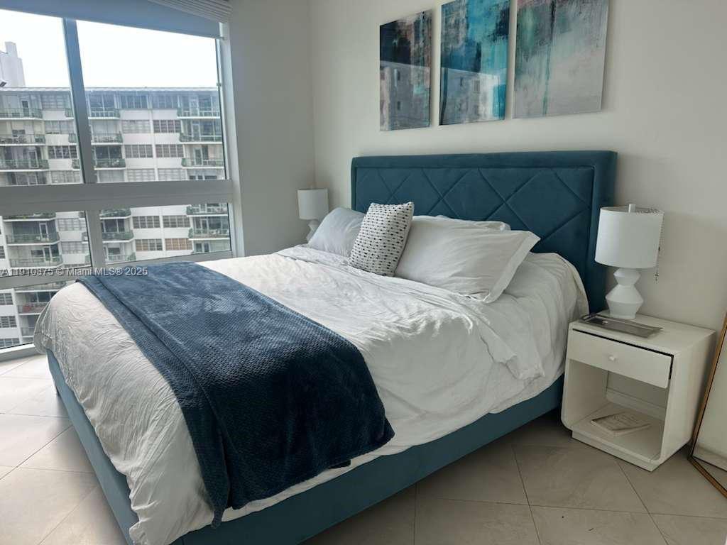 218 Southeast 14th Street, Unit 1003 Miami, FL 33131 - Photo 12 of 27 a bed sitting in a bedroom next to a window