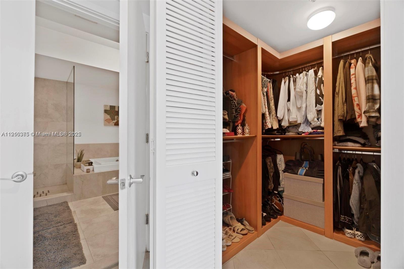 218 Southeast 14th Street, Unit 1003 Miami, FL 33131 - Photo 14 of 27 a view of walk in closet with clothes and shoes