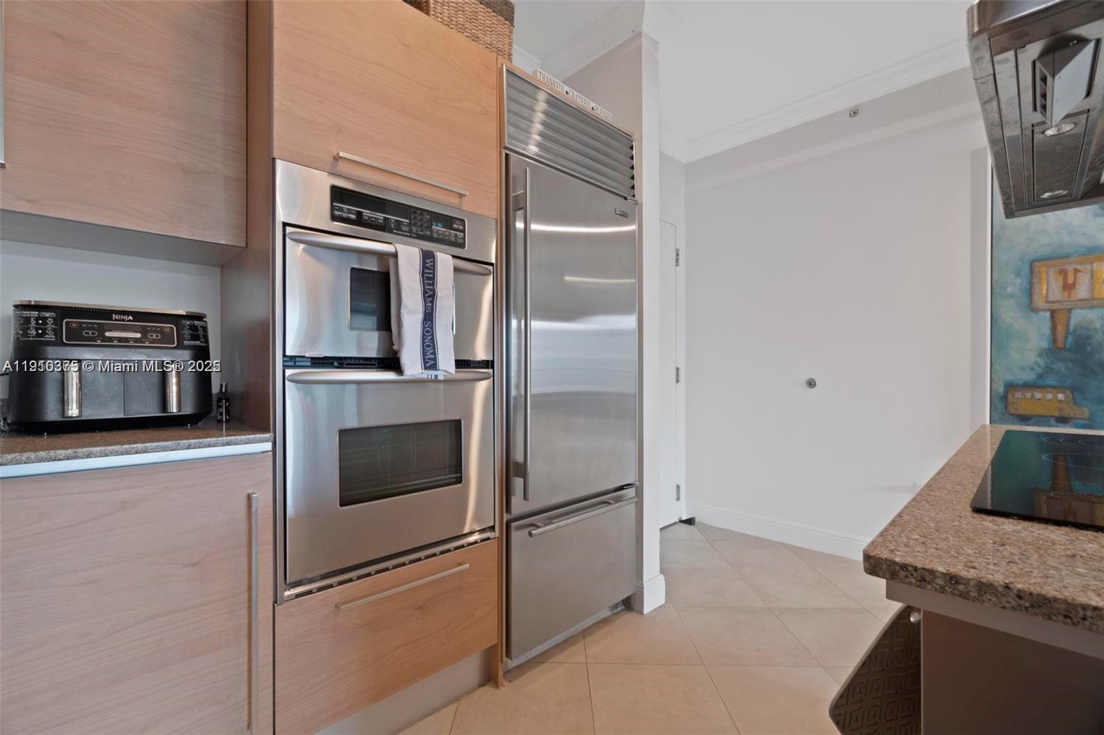 218 Southeast 14th Street, Unit 1003 Miami, FL 33131 - Photo 7 of 27 a kitchen with stainless steel appliances and refrigerator