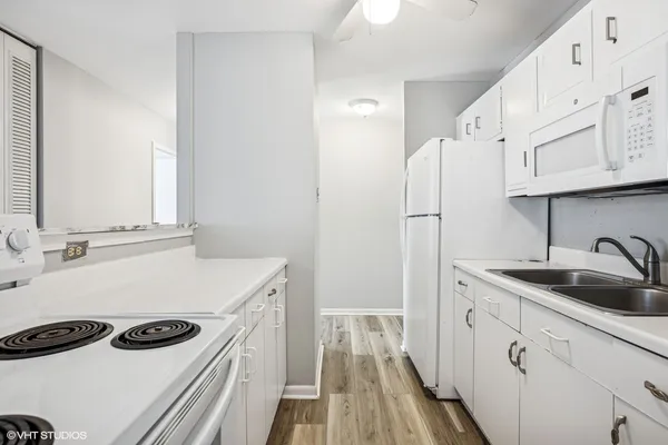 a kitchen with a sink a stove and cabinets