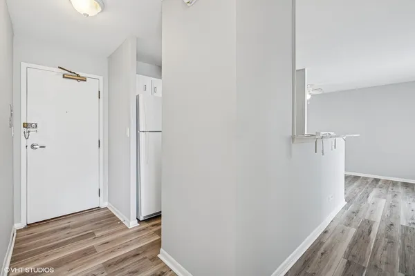 a view of a hallway with wooden floor and closet