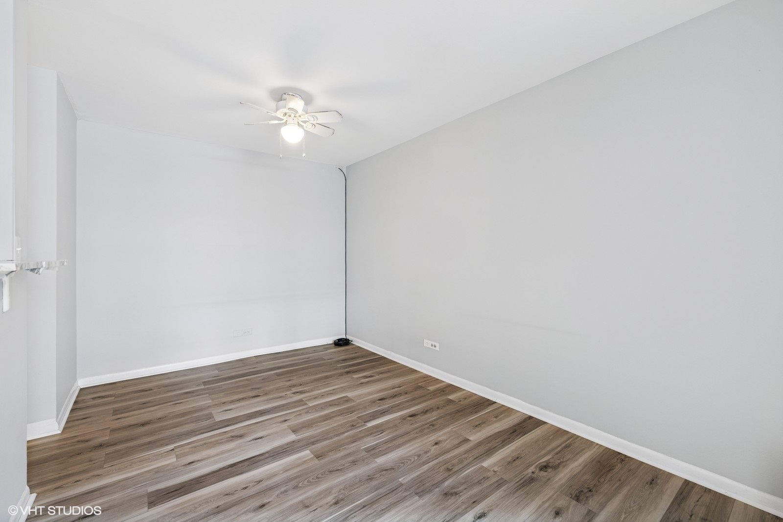 6171 North Sheridan Road, Unit 2404 Chicago, IL 60660 - Photo 19 of 30 an empty room with wooden floor and fan