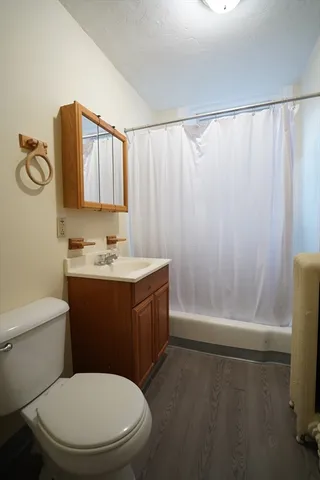 a bathroom with a granite countertop bathtub sink vanity mirror and toilet