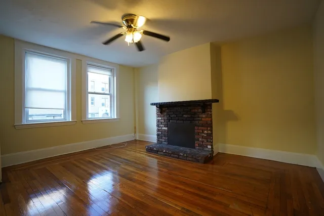a living room with wooden floors and a fireplace