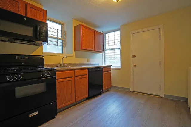 a kitchen with stainless steel appliances granite countertop a stove a sink and a microwave