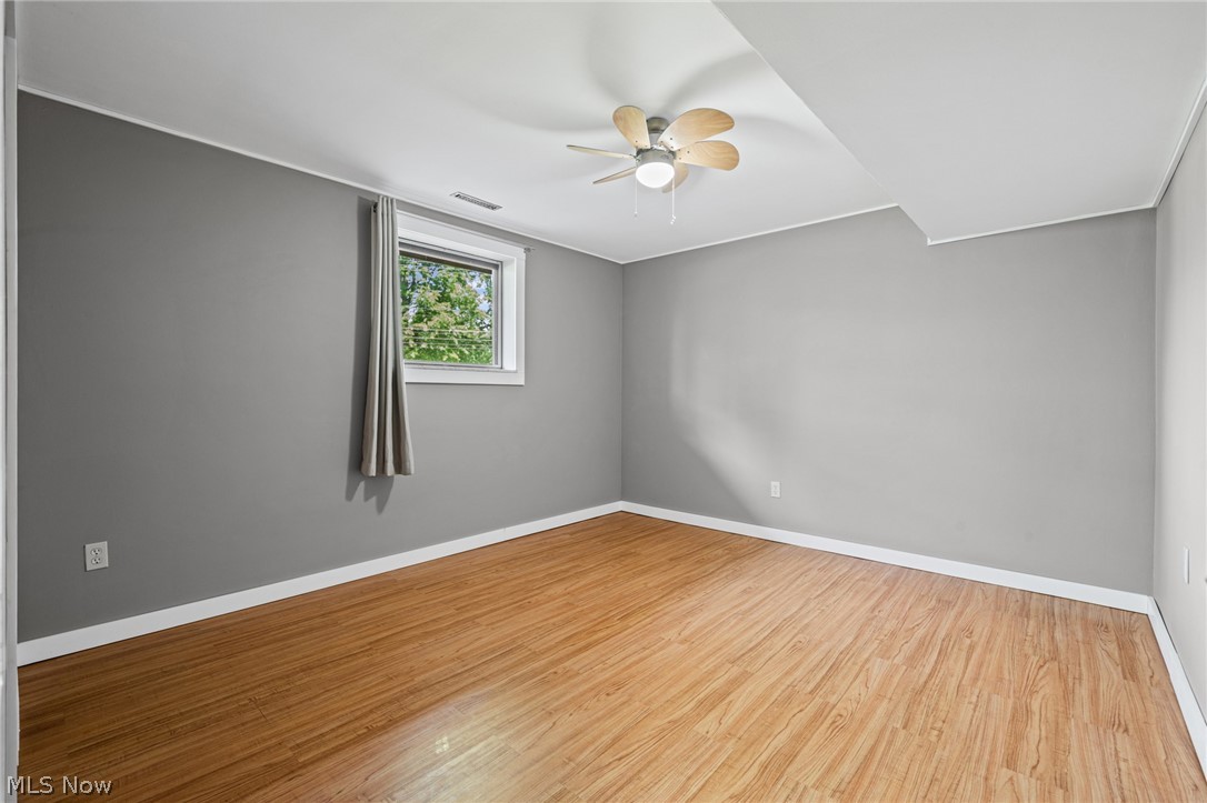 17583 Shurmer Road Strongsville, OH 44136 - Photo 22 of 50 Spacious room featuring wood-finish flooring, light gray walls, white trim, and a ceiling fan with integrated lighting