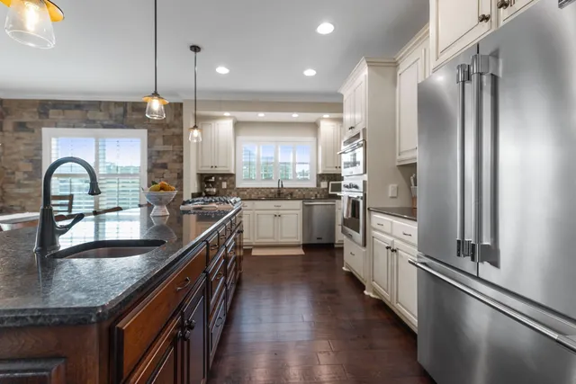 a kitchen with stainless steel appliances granite countertop counter space a sink and a large window