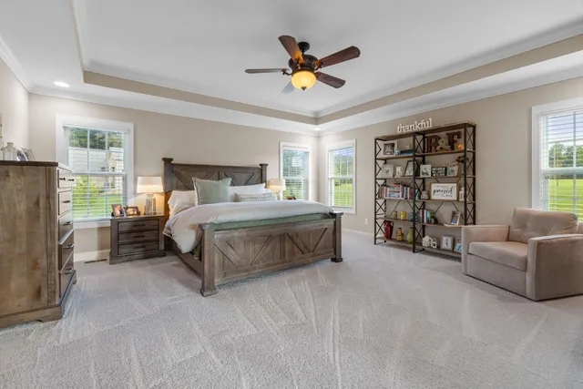 a view of a hallway with wooden floor windows and a bathroom