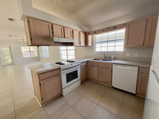 a kitchen with a stove sink and cabinets