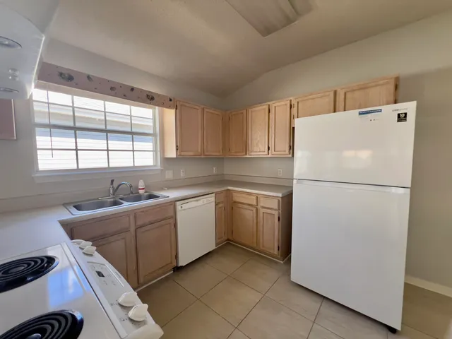 a kitchen with a refrigerator sink and cabinets