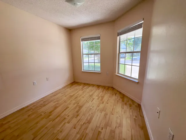 a view of an empty room with wooden floor