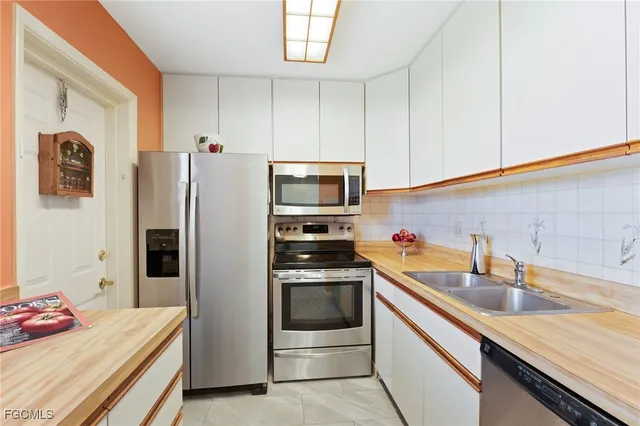 a kitchen with stainless steel appliances a sink stove and refrigerator
