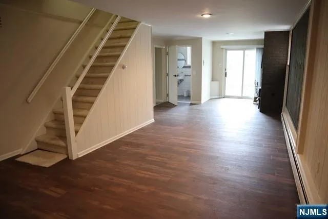 an empty room with wooden floor and stairs