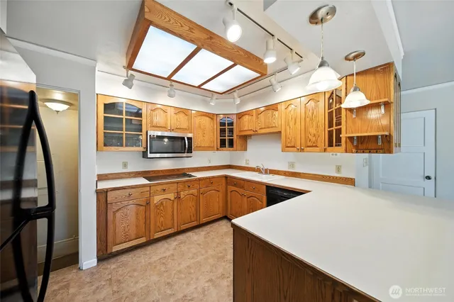 a kitchen with stainless steel appliances granite countertop a sink and a white cabinets